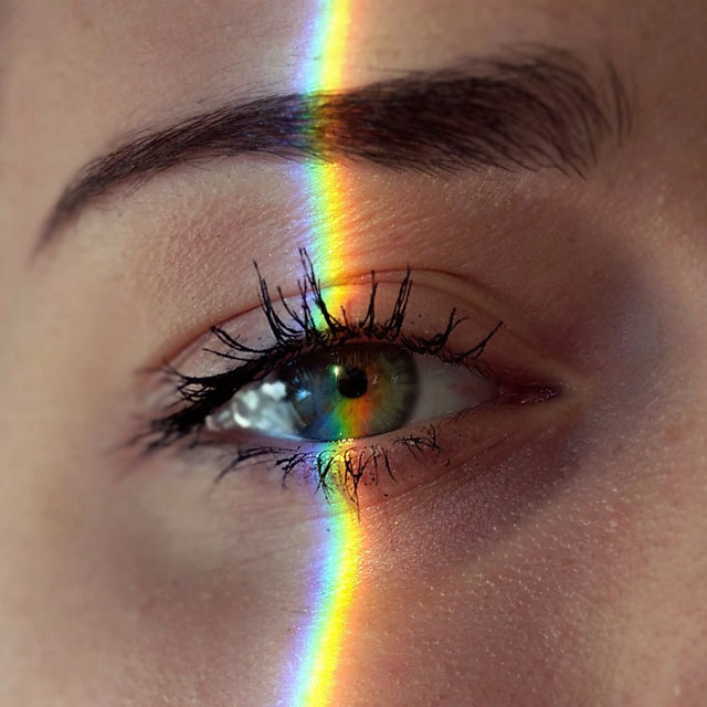 close-up-of-an-eye-with-slice-of-rainbow-light-over-it