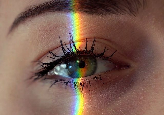 close-up-of-an-eye-with-slice-of-rainbow-light-over-it